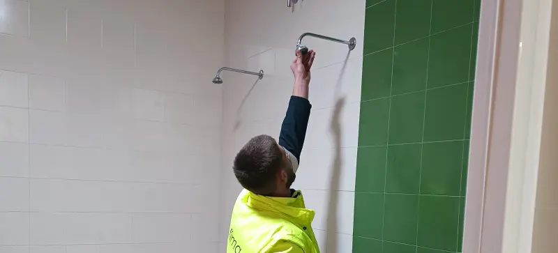 Operario tratando duchas de vestuario de legionella